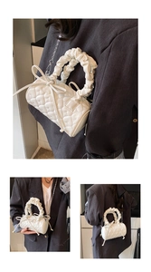 Detail of white heart-quilted cylinder bag with bow and ruffled handle on grey blazer