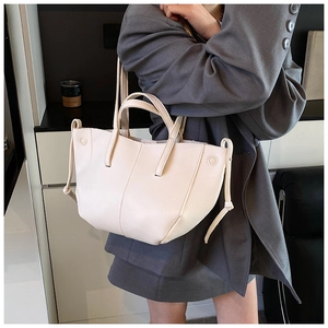 Nahaufnahme der beigen Lychee-Lederstruktur der Achseltasche mit Tunnelzug-Details