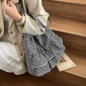 Japanese style black and white gingham tote bag with ruffled skirt design on wooden steps