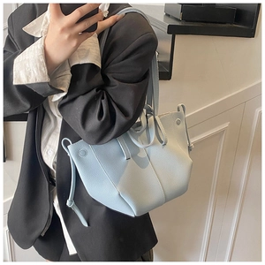 Detail of light blue leather tote bag with unique geometric folding and side drawstrings