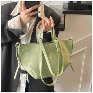 Detailed view of light green lychee textured tote bag with curved design and tie accents
