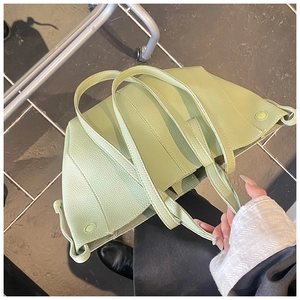 Detail der pistaziengrünen Tragetasche aus genarbtem Leder mit Kordelzug-Akzenten