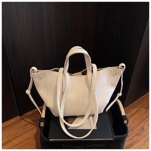 Detail der cremeweißen Tragetasche aus Leder mit Litschi-Struktur und einzigartigem Faltendesign