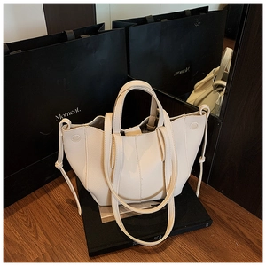 Detail der cremeweißen Ledertasche mit Lychee-Struktur und weichen Tunnelzug-Seiten