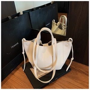 Detailansicht der cremefarbenen Ledertasche mit Litschi-Maserung und Kordelzug-Details