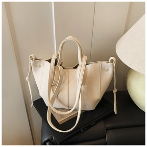 Nahaufnahme der cremefarbenen Schultertasche mit Wellenkante und Lychee-Ledertextur