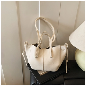 Detail der cremeweißen Ledertasche mit Falten-Design und seitlichem Kordelzug-Detail