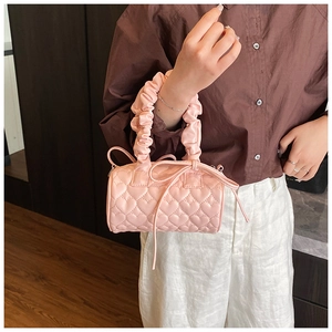 Detail of pink cylindrical pillow bag with heart quilting and ruffled handle design
