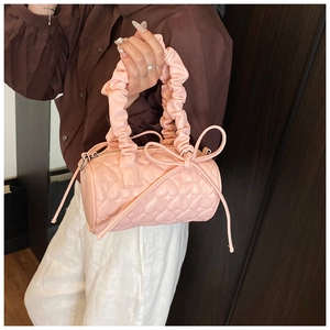 Detailed pink heart-quilted cylinder bag with ruffled handle and ribbon tassel bow