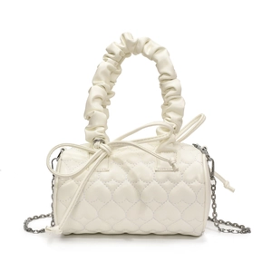 Detail of white heart-quilted cylinder bag featuring unique pleated handle and chain