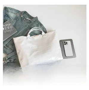Flat lay of white crocodile pattern tote bag with TOTE BAG text and lifestyle props