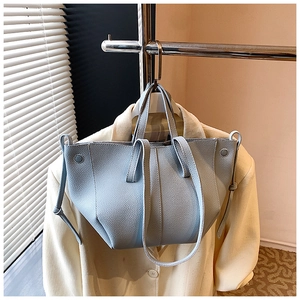 Detail der hellblauen Handtasche mit Lychee-Muster und elegantem Flügel-Design