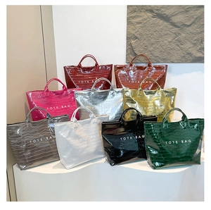 Multiple colors of crocodile pattern tote bags displayed on a minimalist white stand