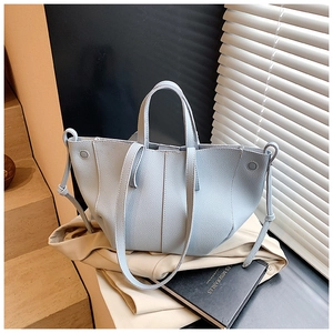 Light blue lychee grain leather tote bag with dual straps shown in a lifestyle setting