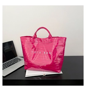 Close-up of magenta faux crocodile leather tote bag with white TOTE BAG lettering