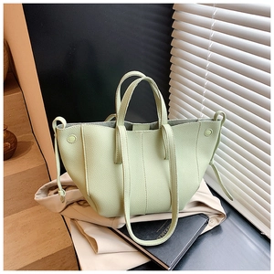 Macro shot of light green lychee-grain leather texture on a minimalist tote handbag