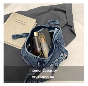 Interior storage view of washed denim tote bag showing space for phone and cosmetics