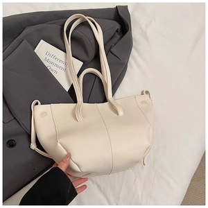Detail der cremigen Lychee-Lederstruktur der Tasche mit Plisseeboden und Metallschnalle