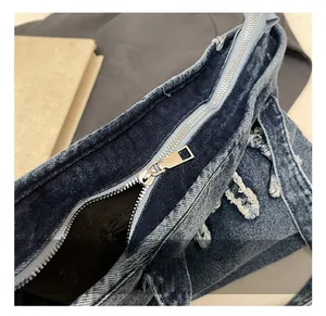 Detailed macro view of vintage denim tote bag with metal zipper and raw edge design