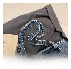 Close-up of denim tote bag showing reinforced double-stitched handles and washed texture
