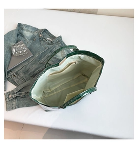 Interior view of green croc-embossed tote bag with spacious lining and zipper pocket