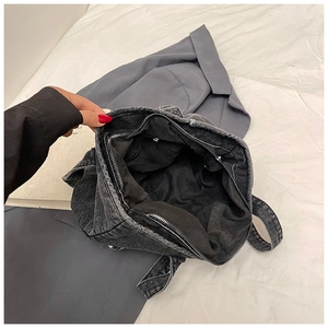 Overhead view of spacious dark grey denim tote interior featuring secure zipper pocket