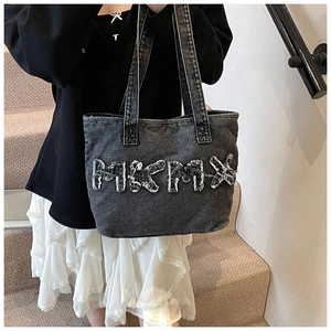 Close-up of MIKMIX patch on distressed denim tote bag with frayed edge detail