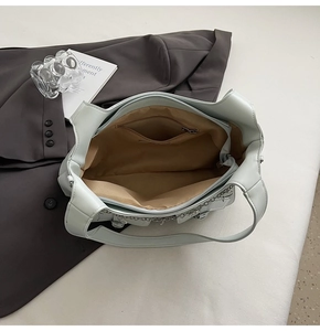 Interior view of mint blue faux leather tote bag with brown lining and zipper pocket