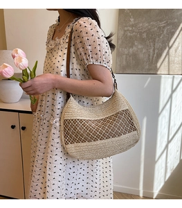 Detail of hand-woven straw shoulder bag with hollow mesh texture and leather strap