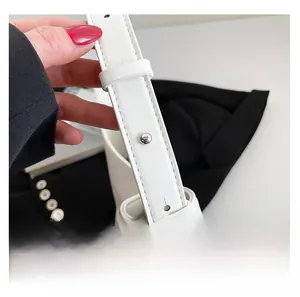 Détail de la bandoulière réglable en cuir blanc avec boucle argentée et coutures de précision