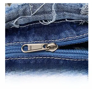 Close-up of high-quality SBS metal zipper on vintage blue denim tote bag with white stitching
