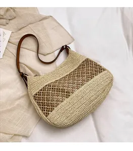 Close-up of hollow woven pattern and brown leather strap on summer straw tote bag