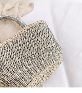 Close-up of metallic woven texture and handle on this casual summer straw tote bag