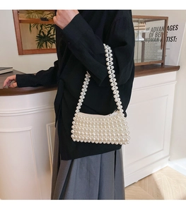 Detailed view of handcrafted white pearl beaded handbag with elegant rectangular shape