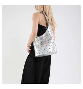 Détail du sac cabas argenté métallisé avec rivets circulaires et design futuriste