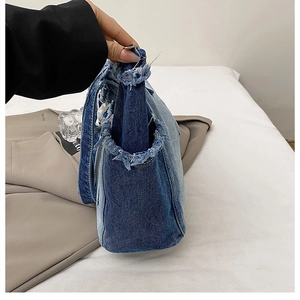 Detailed side view of vintage blue denim tote bag with stylish frayed edges and texture