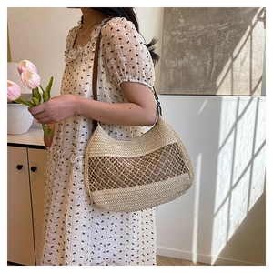 Detail of woven straw shoulder bag featuring large mesh pattern and brown leather strap