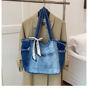 Detail of gradient blue denim tote bag with frayed edges and decorative silk scarf
