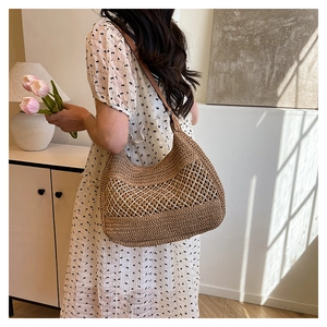 Detail of hand-woven dark brown straw tote with white mesh pattern and leather strap