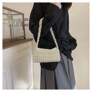 Detail of handmade cream pearl woven shoulder bag with secure top zipper closure