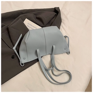 Detailaufnahme der hellblauen Lederstruktur mit Litschi-Muster auf einer minimalistischen Tasche