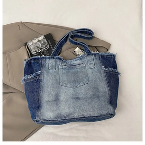 Detailed overhead view of a large patchwork denim tote bag with frayed edges and pockets