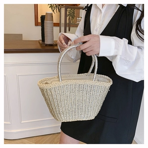 Detailed weave pattern of a beige straw tote bag with elegant silver metallic handles