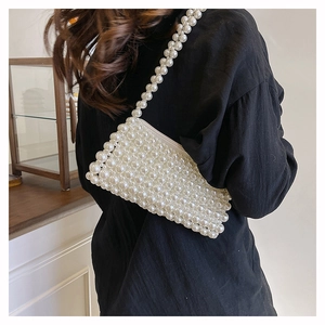 Detail of hand-woven pearl beaded shoulder bag showing intricate craftsmanship and pearly finish