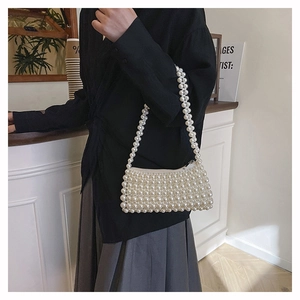 Detail of handmade beaded white pearl shoulder bag with silver zipper closure