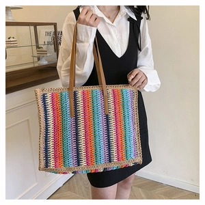 Macro detail of rainbow striped woven tote bag featuring durable brown leather shoulder straps