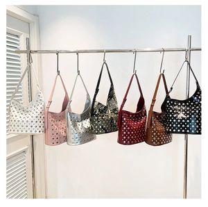 Détail de sacs hobo multicolores avec rivets argentés suspendus sur des cintres