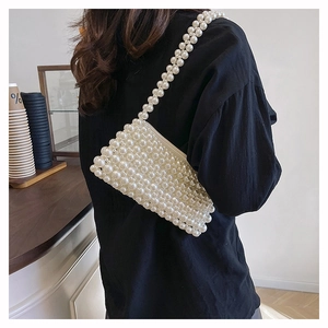 Detailed look at handmade white pearl beaded shoulder bag worn as an underarm purse