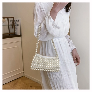 Detail of elegant white pearl beaded handbag with zipper and comfortable shoulder strap