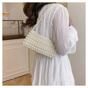 Detail of white handmade pearl shoulder bag with lustrous beads and zip closure
